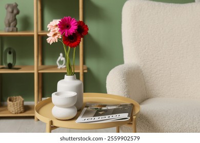 Vase with gerbera flowers and magazine on table in living room - Powered by Shutterstock