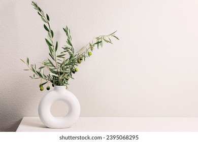 Vase with olive tree branches over the light gray wall, modern minimal design interior - Powered by Shutterstock