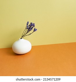 Vase Of Purple Dry Flower On Orange Table. Yellow Wall Background. Home Interior