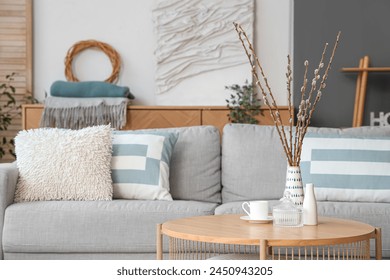 Vase with willow branches and cup on table in living room - Powered by Shutterstock