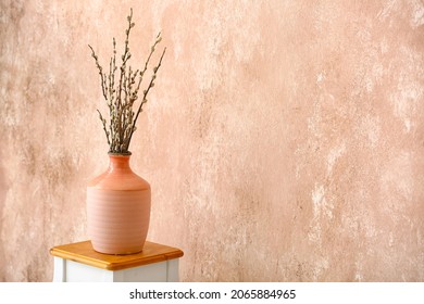 Vase with willow branches on table near color wall - Shutterstock ID 2065884965