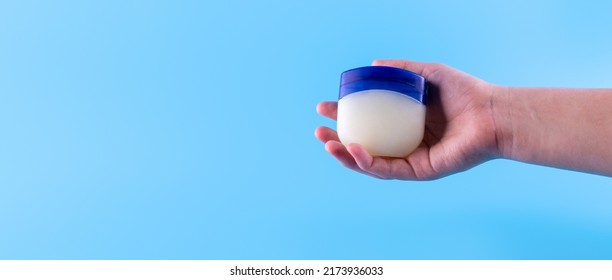 Vaseline Or Petroleum Jelly In A Clear Jar On Blue Background With Copy Space For Text. Skin Care Ointment