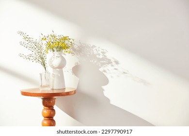 Vases and objects on the table in a warm room with sunlight coming in