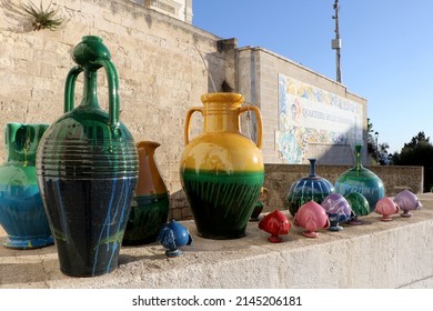 Vases and pumi in the ceramic district in Grottaglie. Writing on the wall in Italian "Città della Ceramica" in english "City of Ceramics". Puglia, Italy - Shutterstock ID 2145206181