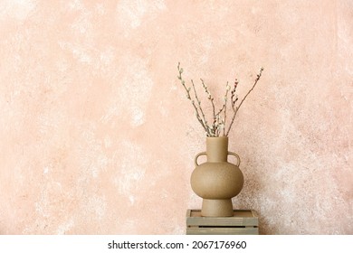 Vases with willow branches on table near color wall - Shutterstock ID 2067176960