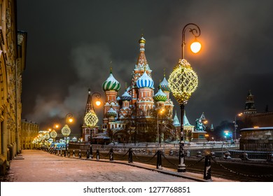 Vasilevsky descent in the winter snowy night. Illuminated Saint Basil`s Cathedral, Kremlin wall and Middle lines on Red Square in Moscow.