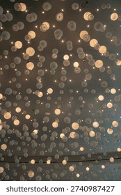 A vast array of translucent spheres and tiny lights hang from a ceiling, creating a mesmerizing and ethereal visual display