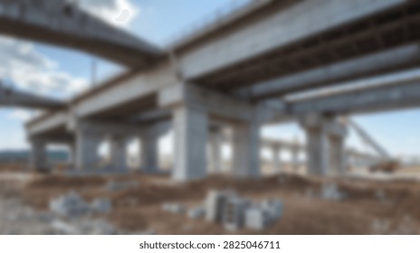 A vast construction site featuring a massive concrete highway overpass supported by numerous pillars under a clear blue sky.