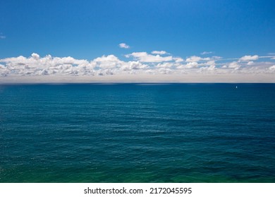 The vast and deep Atlantic ocean, blue sky and white clouds on the horizon in Portugal. Front view seascape background with empty space for text