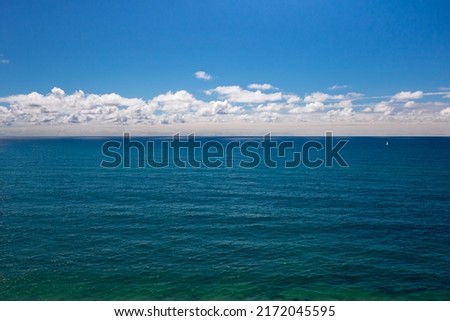 The vast and deep Atlantic ocean, blue sky and white clouds on the horizon in Portugal. Front view seascape background with empty space for text