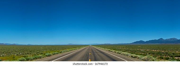 Vast Endless Stretch Of Open Road In Western America Carries On Into The Distance.