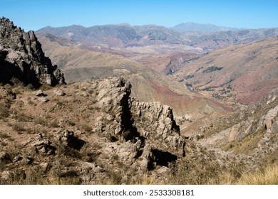 A vast mountainous landscape surrounding Maragua in Bolivia, featuring rugged rock formations, arid terrain, and sweeping views of the Andes Mountains under a clear sky. - Powered by Shutterstock