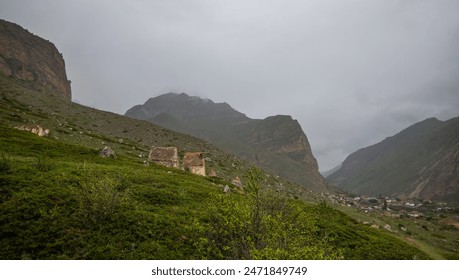 a vast mountainous landscape under an overcast sky. Rolling hills with varying shades of green . A winding road cuts through the valley. Small structures are visible in the distance. - Powered by Shutterstock