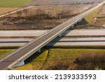 A vast plain. A collision-free intersection of two roads. One of them is two-lane, the other runs along the flyover. View from the drone.