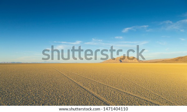 Vast Playa at Black Rock Desert with Tire Tracks on\
Empty Cracked Mud.