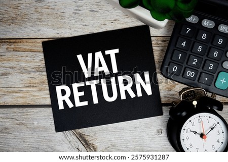 Vat return text with alarm clock and calculator on wooden background, Business concept