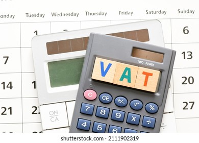 VAT Word Arranged With Wooden Letters On The Calculator Screen. Settlement VAT In Poland.