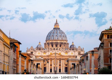 Vatican City. Sunrise over the St. Peters Basilica in Vatican City. Morning at the most famous landmark, empty of people street, cloudy sky.