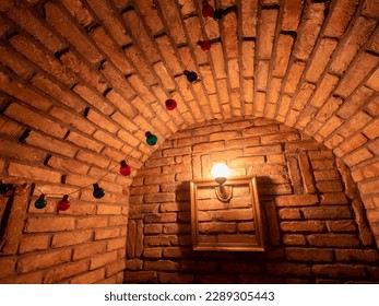 Vaulted wine cellar
 ceiling with red bricks and yellow light