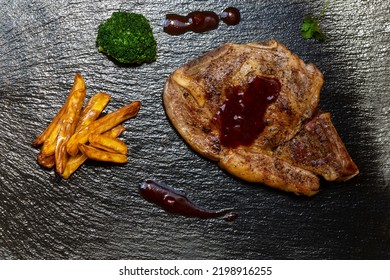 Veal Cutlet And French Fries On Slate