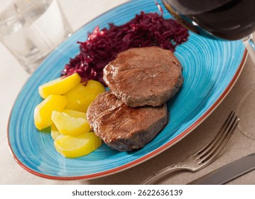 Veal Medallion de cadera with potato and sauerkraut..Healthy roasted beef steak served with baked potatoes and pickled cabbage..Grilled veal steak with boiled potato and marinated cabbage