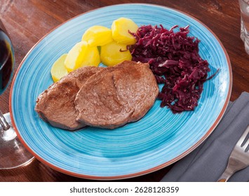 Veal Medallion de cadera with potato and sauerkraut..Healthy roasted beef steak served with baked potatoes and pickled cabbage..Grilled veal steak with boiled potato and marinated cabbage