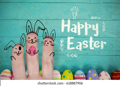 Vector image of fingers painted as Easter bunny against various easter eggs arranged on wooden surface