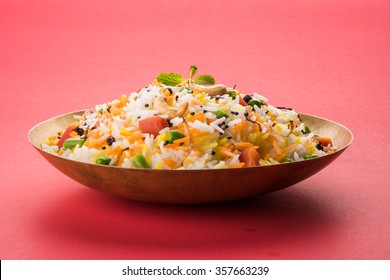 Veg Biryani Served In A Round Brass Bowl Over Wooden Background
