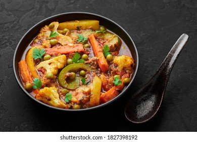 Veg Kolhapuri In Black Bowl On Dark Slate Table Top. Indian Vegetable Curry Dish. Vegetarian Asian Food And Meal.