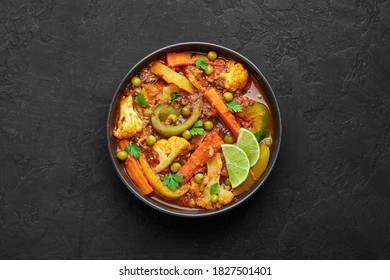 Veg Kolhapuri In Black Bowl On Dark Slate Table Top. Indian Vegetable Curry Dish. Vegetarian Asian Food And Meal. Top View