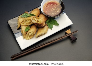 Veg. Spring Rolls, on white&black dish and black table / Selective focus.