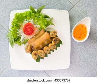 Veg. Spring Rolls with sweet sauce, on white dish and brown cloth / Selective focus, top view