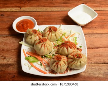 Veg Steam Momo.topped With Peri Peri Masala And Served With Sauce And Mayonnaise Over A Rustic Wooden Background, Selective Focus