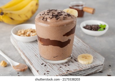 Vegan banana chocolate ice cream with chocolate glaze and sprinkles in a glass on a gray concrete background. Healthy food. Copy space - Powered by Shutterstock