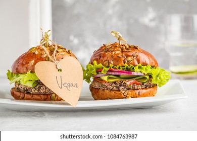 Vegan black bean burgers with vegetables and tomato sauce on white dish, copy space. Healthy vegan food concept. - Shutterstock ID 1084763987