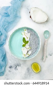 Vegan Blue Spirulina Smoothie And Chia Pudding Bowl Topped With Coconut Flakes And Lime Zest. Overhead, Flat Lay, Top View