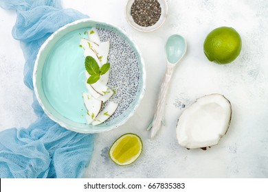 Vegan Blue Spirulina Smoothie And Chia Pudding Bowl Topped With Coconut Flakes And Lime Zest. Overhead, Flat Lay, Top View