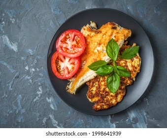Vegan breakfast with cabbage pancakes and fried fish, tomatoes and basil