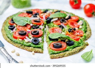 Vegan Broccoli Zucchini Pizza Crust With Spinach Pesto, Tomatoes, Onion And Olives. Toning. Selective Focus