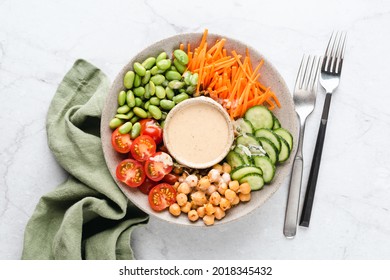 Vegan Buddha Bowl Salad With Chickpeas, Vegetables, Edamame Beans And Cashew Sauce