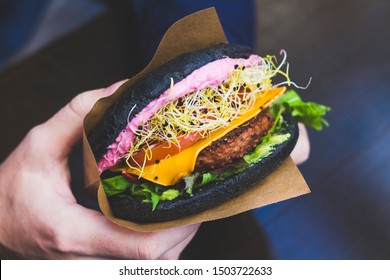 Vegan burger with black bun, cres salad, cheddar cheese, patty, pink mayonnaise, patty and tomatoes - Powered by Shutterstock