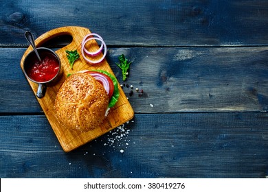 Vegan Burger With Fresh Vegetables On Dark  Rustic Wooden Table, Top View, Border. Healthy Fast Food Background With Space For Text. 