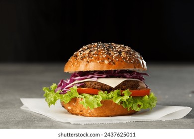 Vegan burger with vegetables and sauce on dark background. Healthy food concept. - Powered by Shutterstock