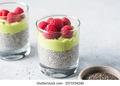 Vegan chia seed pudding with avocado mousse layer and topped with fresh raspberries. Healthy breakfast or snack food rich in Omega 3 fatty acids