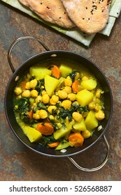 Vegan Chickpea Curry Or Chana Masala With Spinach, Potato And Carrot, Served With Naan Bread, Photographed Overhead On Slate With Natural Light