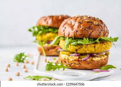 Vegan chickpeas burgers with arugula, pickled cucumbers and hummus. Plant based diet concept. - Shutterstock ID 1239647506