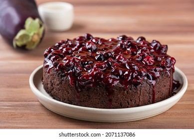 Vegan chocolate cake with berry jam on a wooden table. Sugar, gluten and lactose free.
