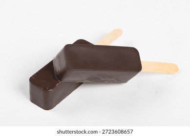 Vegan Chocolate cake is rectangular in shape. On a wooden stick. White background. Close-up