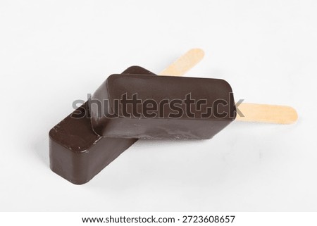 Vegan Chocolate cake is rectangular in shape. On a wooden stick. White background. Close-up