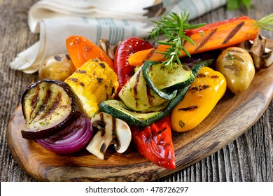 Veganische Küche: gegrilltes gemischtes Gemüse auf Holzbrett